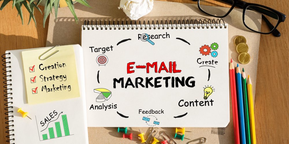 Notebook with Tools and Notes about E-mail Marketing strategy